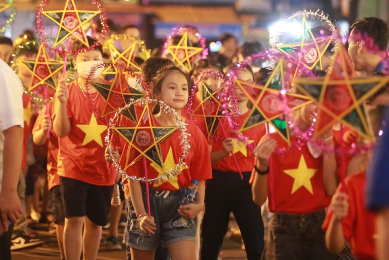 Các em thiếu nhi mặc áo đỏ sao vàng rước đèn ông sao