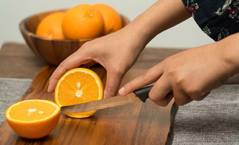 Cắt đôi quả cam đúng kích thước phù hợp với đầu máy vắt cam