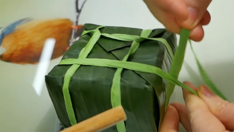 Luồn sợi dây dài xuống phía dưới đáy bánh và xoắn 90