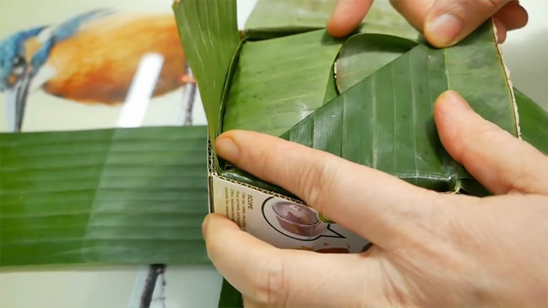 Dàn đều nguyên liệu vào bên trong khuôn bánh đã chuẩn bị và gấp lá
