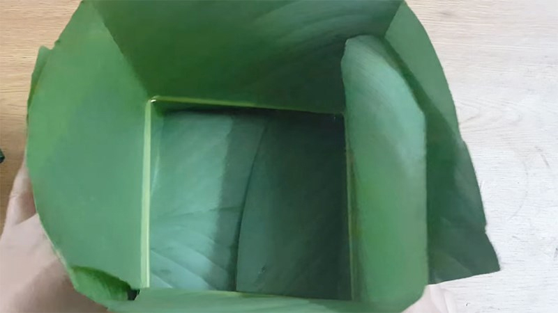 Xếp các lá đã gấp lại thành hình khuôn vuông và luồn dây lạt xuống dưới