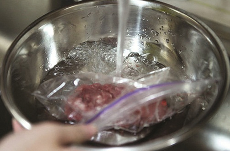 Đặt túi thịt dưới vòi nước lạnh để rã đông